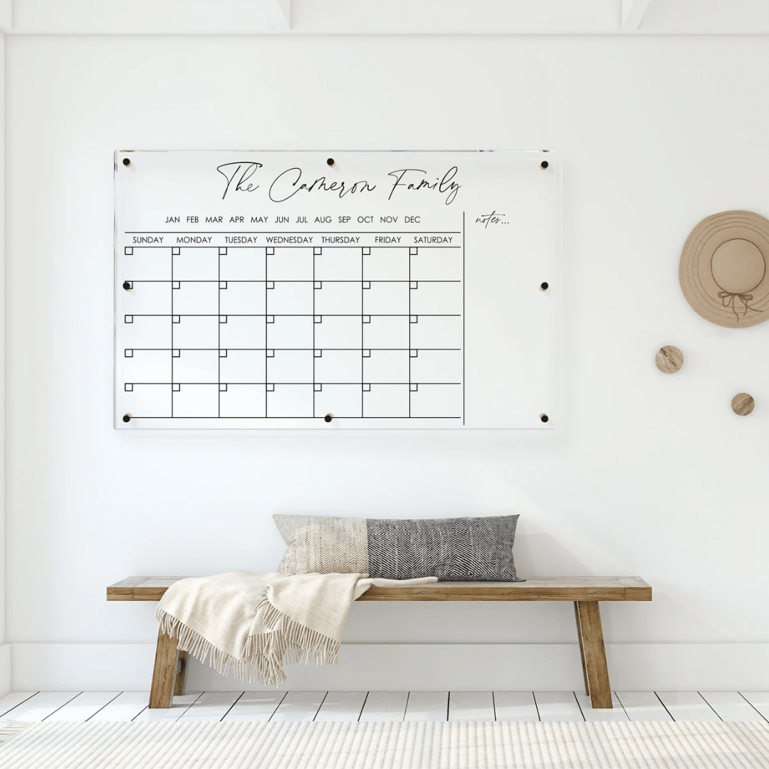 A personalized wall featuring a wooden bench and an acrylic calendar.