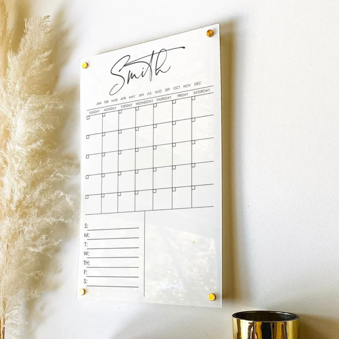 A wall calendar hanging on a wall next to a vase.