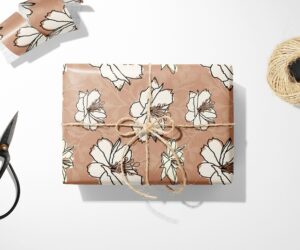 A Floral Wrapping Paper with a bow and scissors on a white surface.