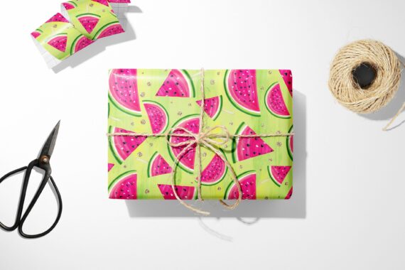 Watermelon Fruit Wrapping Paper and scissors on a white surface. Perfect for a summer birthday gift.