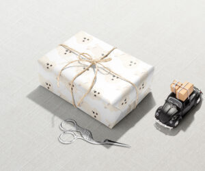 A White Poodle Wrapping Paper gift box with a pair of scissors next to it.