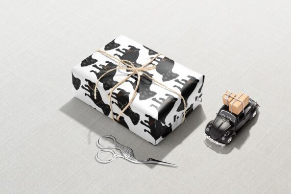 A Black Pug Dog Wrapping Paper decorated with scissors and a toy car.