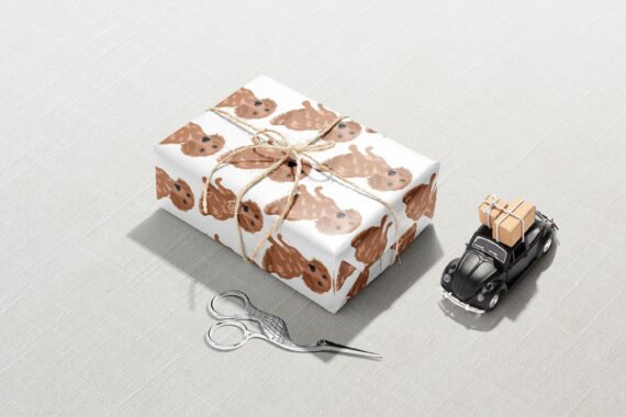 A Christmas gift box with a pair of scissors wrapped in Brown Dog Wrapping Paper.