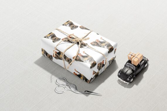 A Rottweiler Dog wrapping paper with a car and scissors next to it.