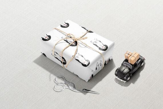 A pair of scissors and a Cavalier King Charles Spaniel Wrapping Paper next to a Christmas wrapping paper.