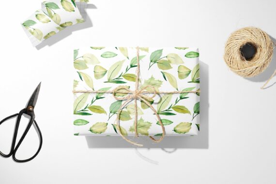 A Green Leaves Wrapping Paper with scissors next to it.