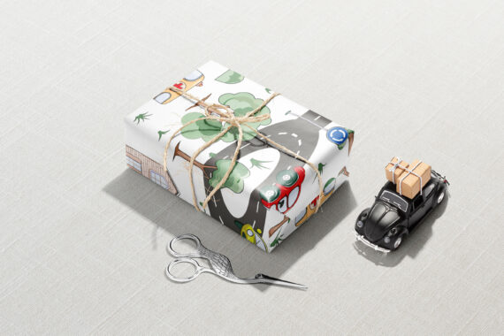 A gift wrapped with Cars, Roads, and Town Wrapping Paper and a toy car.