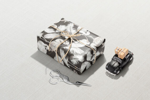 A pair of scissors and a White Flamingo Wrapping Paper wrapped in black and white wrapping paper.