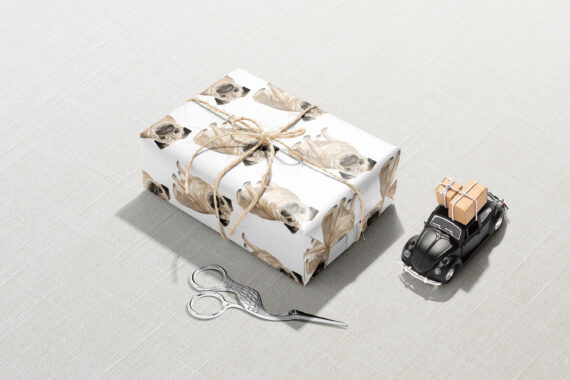 Sentence with product name: A Pug Dog Wrapping Paper with a pug on it and a pair of scissors.