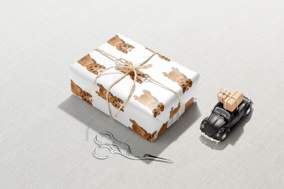 A gift box with a car and scissors next to it, wrapped in Yorkshire Terrier Wrapping Paper.